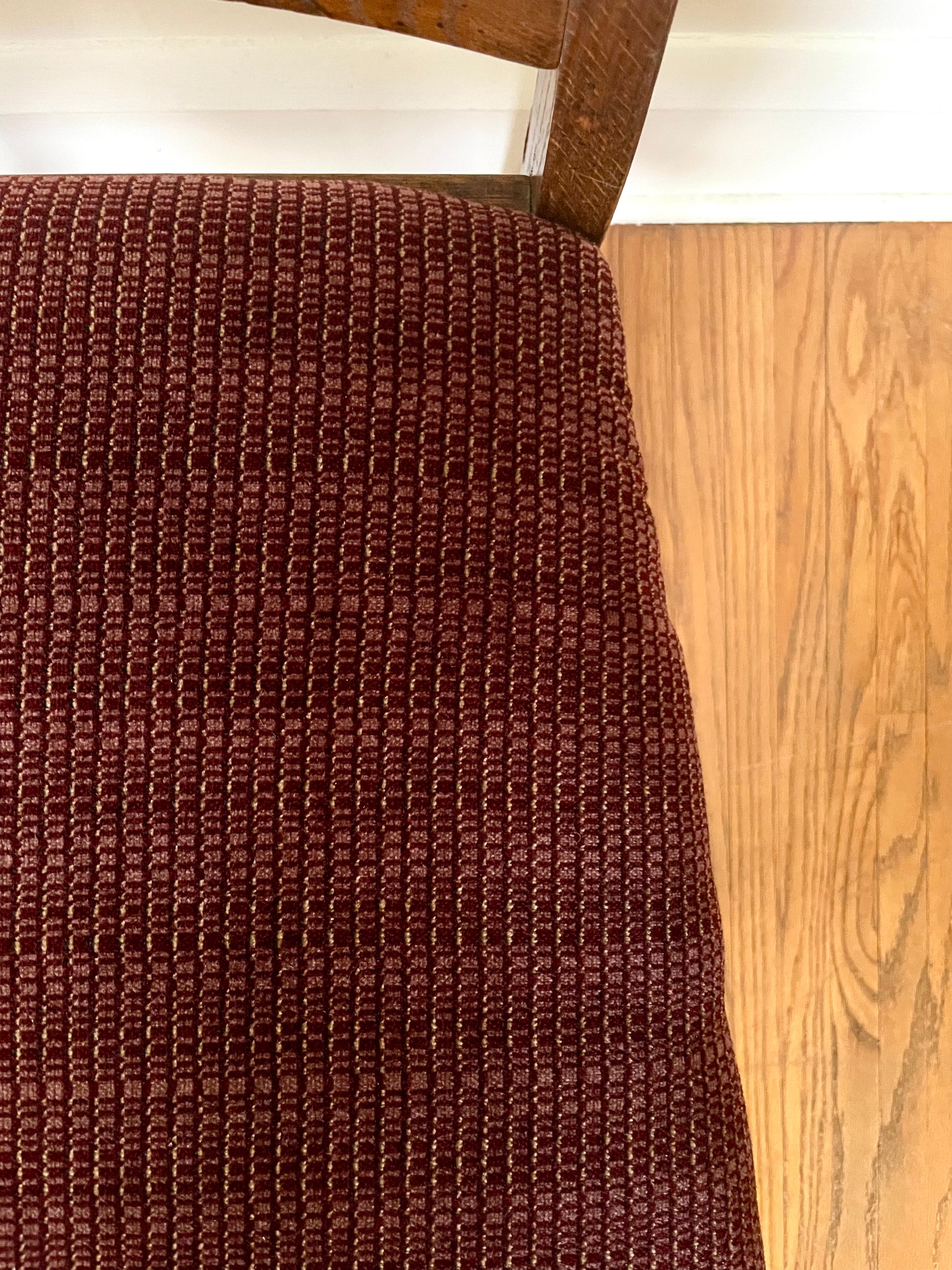View from above of a dark red textured upholstered seat.