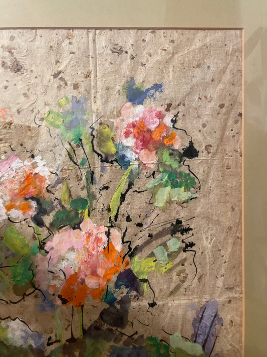 An abstract floral painting on textured beige paper, featuring expressive brushstrokes in pink, orange, green, blue, and black, framed by a beige mat.