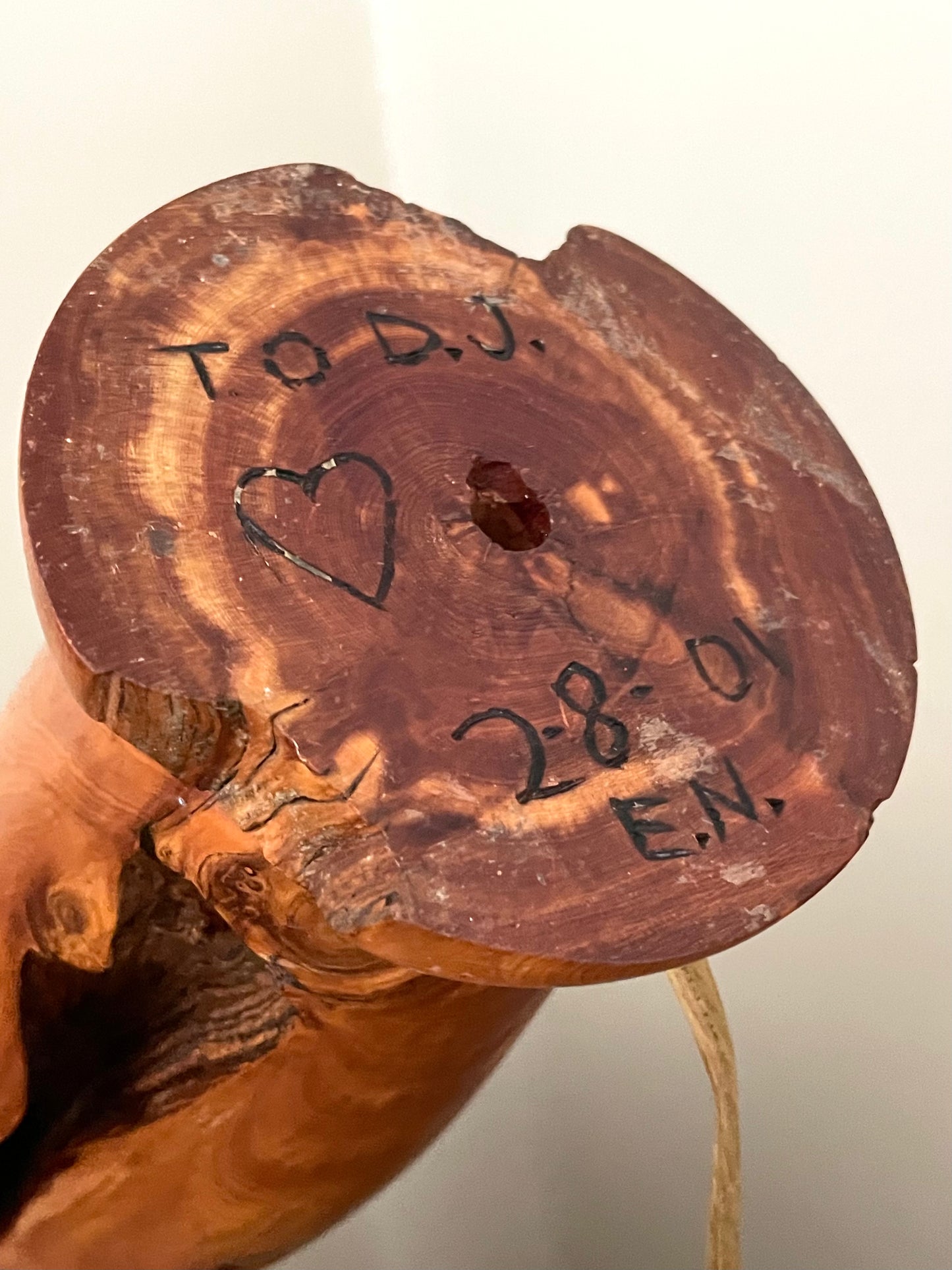 A close-up of the underside of a wood lamp, showing engraved text reading ‘To D.J. 2-8-01 E.N.’.