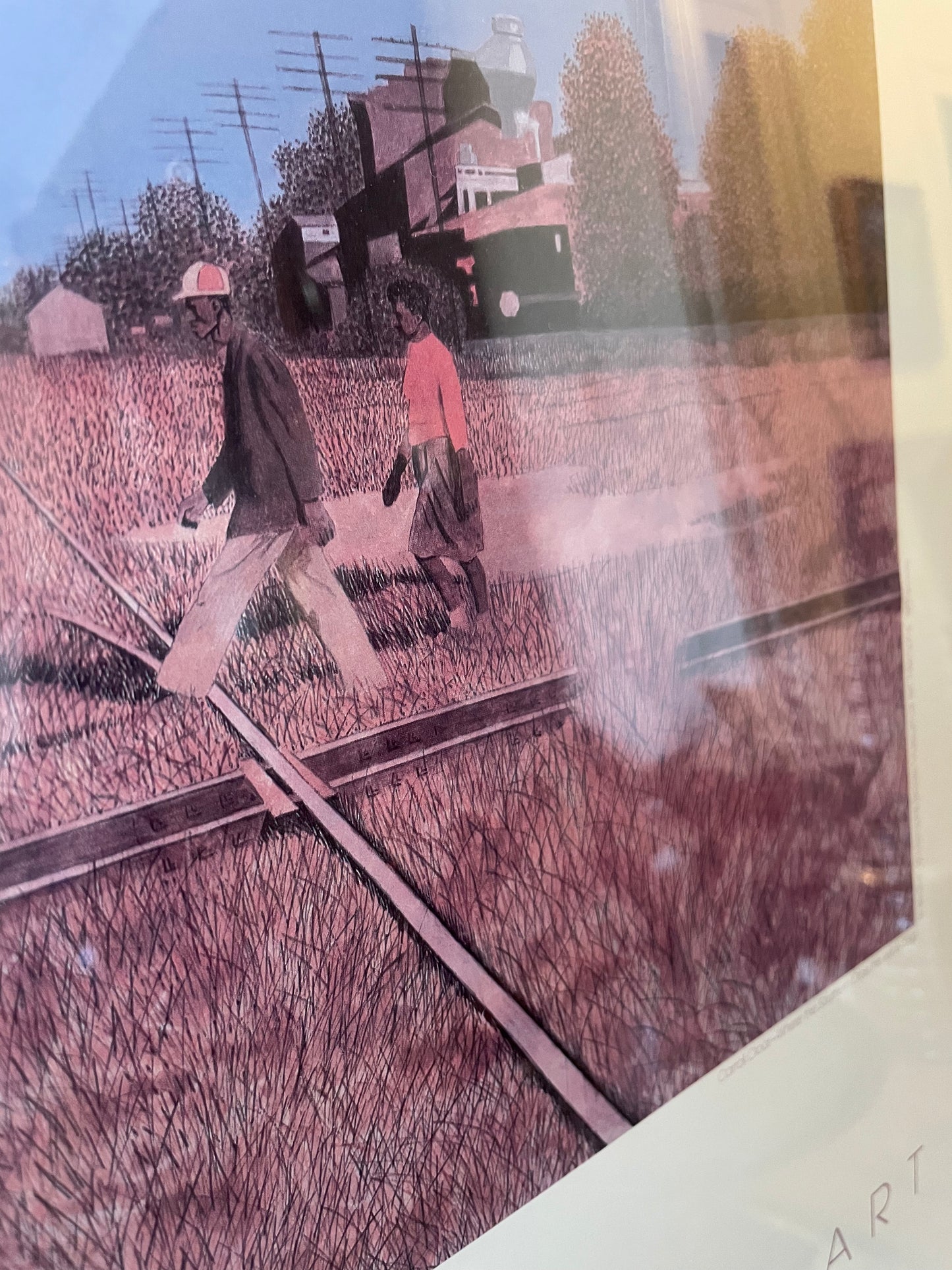 Closeup of an art print showing two people walking along railroad tracks in a field, with a train and trees in the background. The artwork has a strong pinkish-purple tint and is photographed at an angle with part of a white border visible.