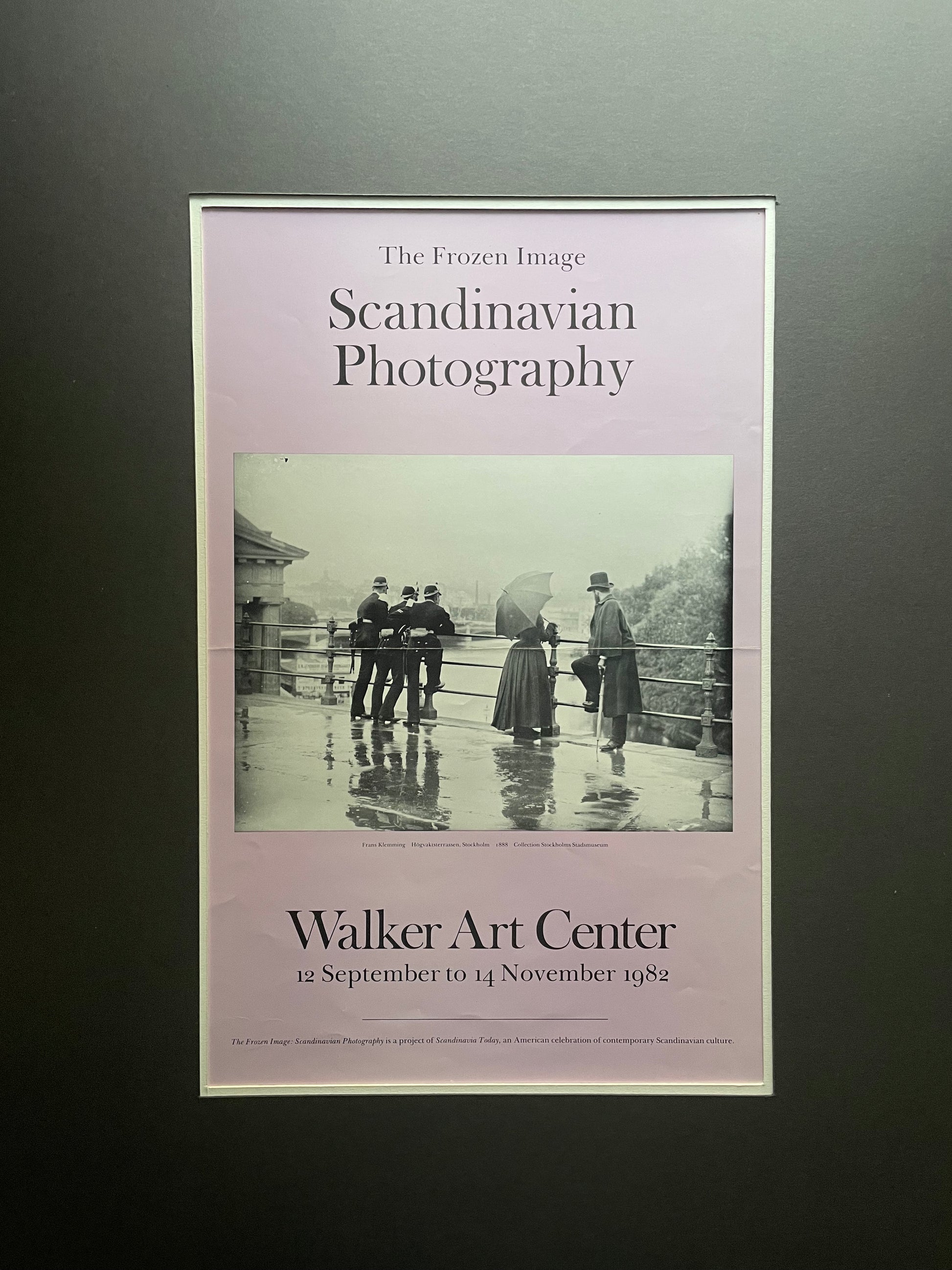 A framed poster titled 'The Frozen Image: Scandinavian Photography' mounted on a dark gray mat. The poster has a lavender background with a central black-and-white historical photograph and text reading 'Walker Art Center' and dates '12 September to 14 November 1982'.