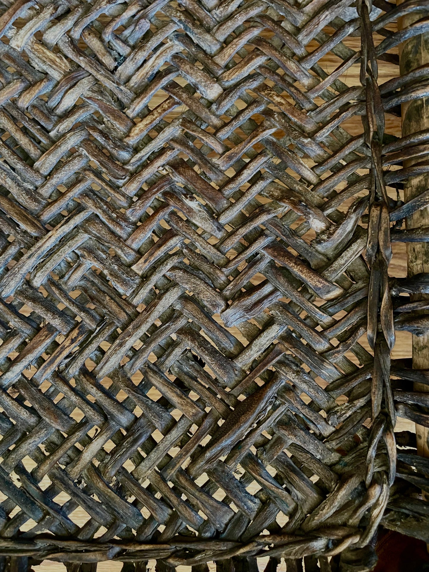 Close-up of a dark brown woven chair seat, showing the detailed texture of the natural fibers.