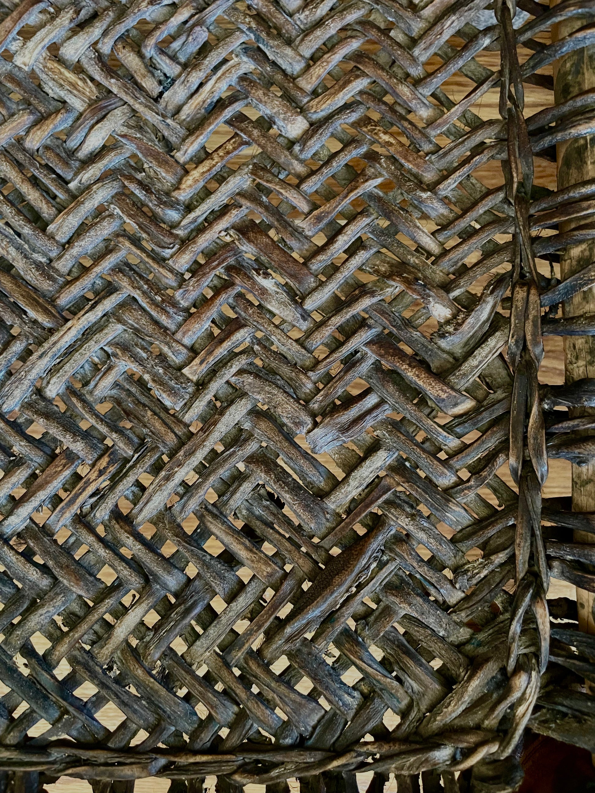 Close-up of a dark brown woven chair seat, showing the detailed texture of the natural fibers.
