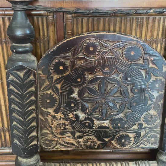 Video showing close-up details of two distressed hand-carved wooden chairs with woven seats and short turned legs.