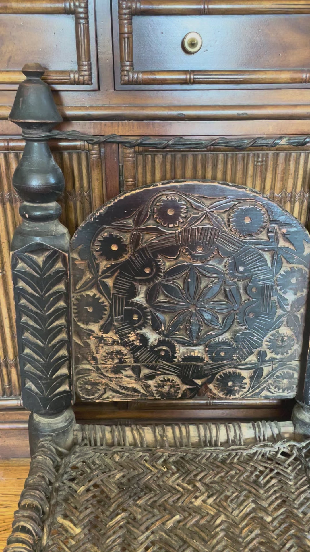 Video showing close-up details of two distressed hand-carved wooden chairs with woven seats and short turned legs.