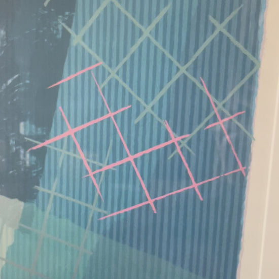 Video showing closeup scan of a framed abstract art print. The artwork features a complex composition of blue, teal, red, pink and mauve geometric patterns, enclosed in a white mat and a dark teal frame.